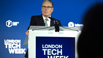 Keir Starmer at tech event discussing innovation and policy, surrounded by tech leaders and digital displays