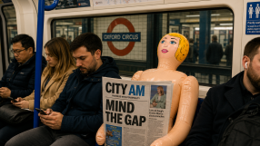 Abandoned doll on London Tube seat holding City AM newspaper, capturing urban life and public transport atmosphere