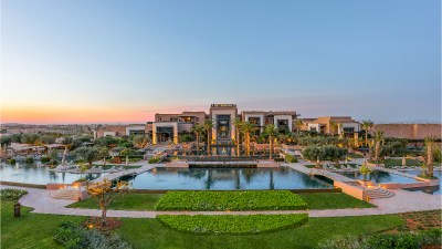 Fairmont Marrakech luxury hotel exterior with lush gardens and elegant architecture under clear blue skies