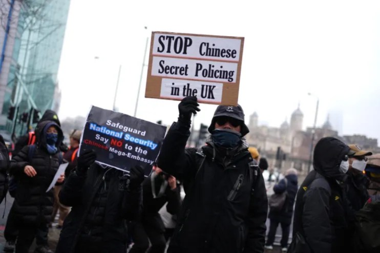Protesters hold signs saying STOP Chinese Secret Policing in the UK and Safeguard National Security