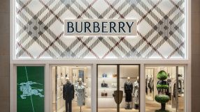 Burberry store facade with classic plaid pattern, logo, display windows featuring mannequins and handbags