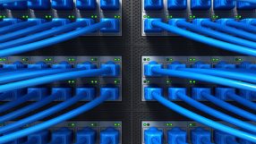 Close-up of vibrant fibre optic cables with glowing blue and green lights, symbolizing fast internet connectivity and data...
