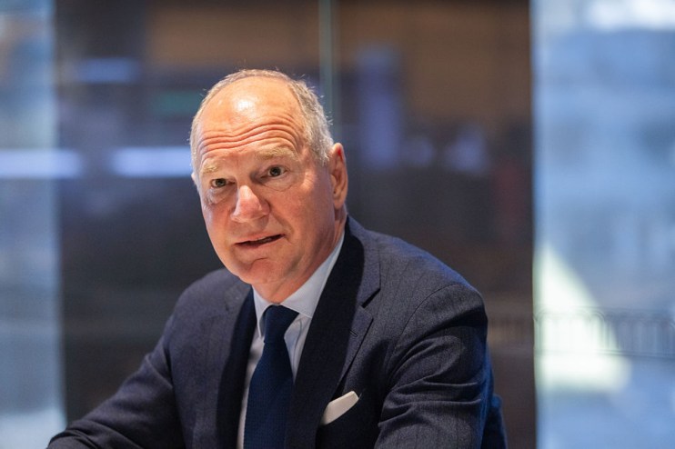 Heathrow CEO Thomas Woldbye in a dark suit and tie, looking forward with a serious expression in an office setting.