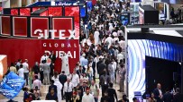Crowd of diverse attendees at GITEX GLOBAL DUBAI tech exhibition, with GITEX signage visible.