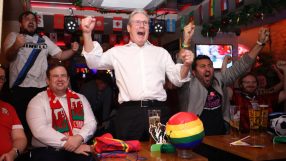 Keir Starmer holding a football with a World Cup logo, smiling and engaging in a sports event discussion.