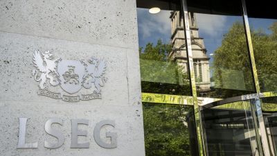 LSEG building entrance with company logo and reflections of a church tower and trees in the glass facade