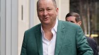 Mike Ashley in a business setting, wearing a suit, likely discussing sports retail strategy or recent business developments.