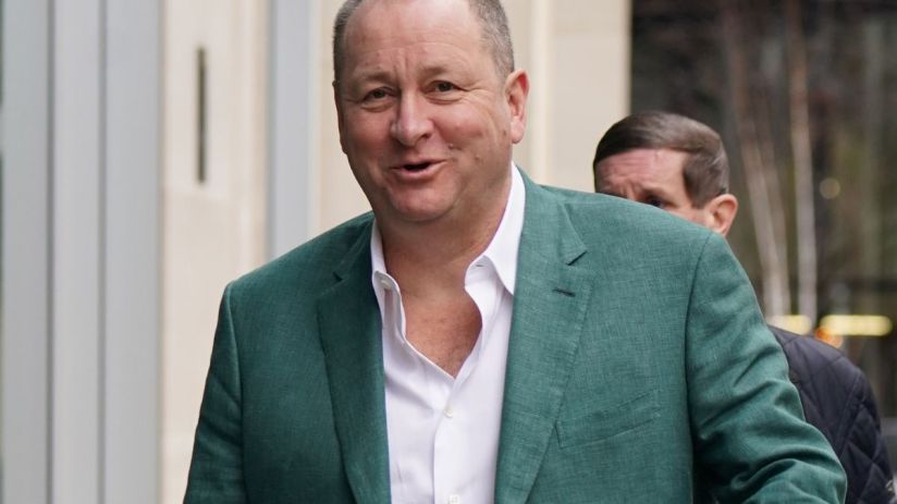 Mike Ashley in a business setting, wearing a suit, likely discussing sports retail strategy or recent business developments.