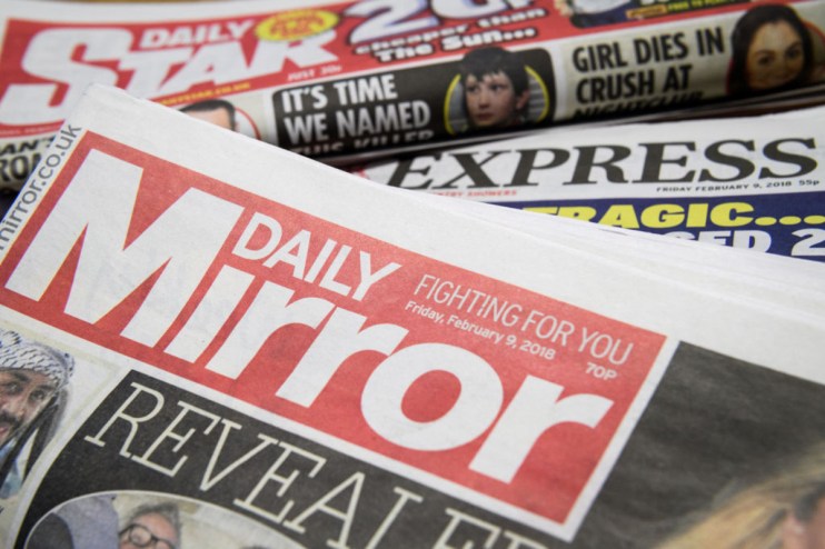 Stack of newspapers including Daily Mirror, Daily Express, and Daily Star, showcasing headlines and mastheads.