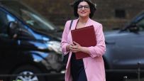 Shabana Mahmood speaking at a podium during a public event, wearing a formal suit, addressing an audience with confidence.