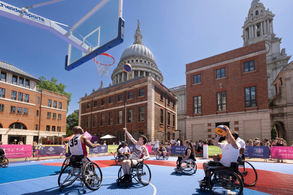 Pemain bola basket kursi roda di lapangan biru selama sesi komunitas Festival Olahraga London, Katedral St. Pauls di ba...