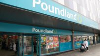 Exterior view of a Poundland store entrance with its teal blue signage and glass doors