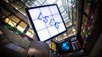 LSEG signage and digital stock market ticker displays inside a modern financial building.