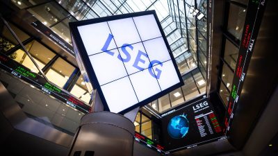 LSEG signage and digital stock market ticker displays inside a modern financial building.