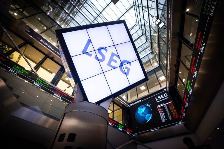LSEG signage and digital stock market ticker displays inside a modern financial building.