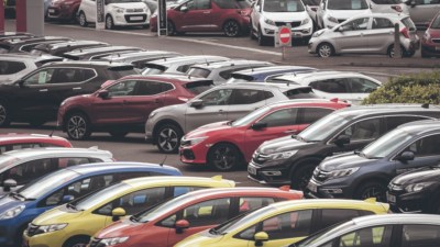 Rows of new and used cars parked at a dealership lot, ready for sale.