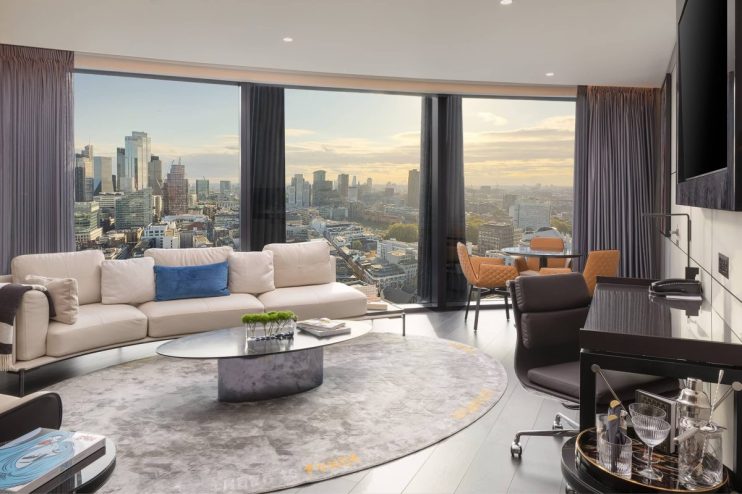 Luxurious one-bedroom suite living room at Artotel London Hoxton with city skyline views.