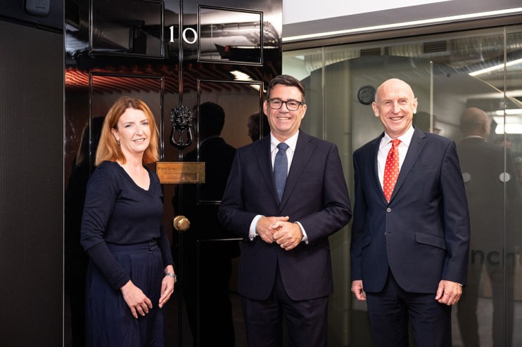 Andy Burnham, John Healey, and Louise Haigh by a doorway, discussing tax policy for a news article.
