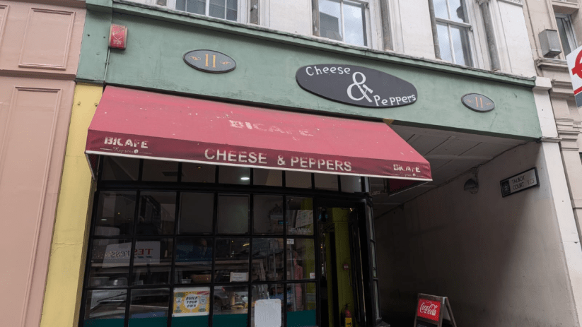 Exterior of Cheese & Peppers cafe at 11 Talbot Court, featuring a red awning and storefront.