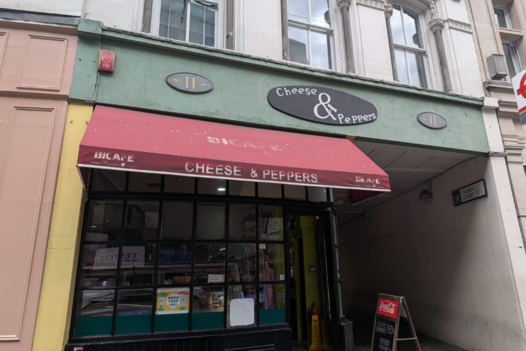 Exterior of Cheese & Peppers cafe at 11 Talbot Court, featuring a red awning and storefront.