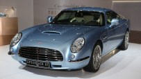 Light blue David Brown Automotive Speedback GT sports car, front 3/4 view, at an auto show display.
