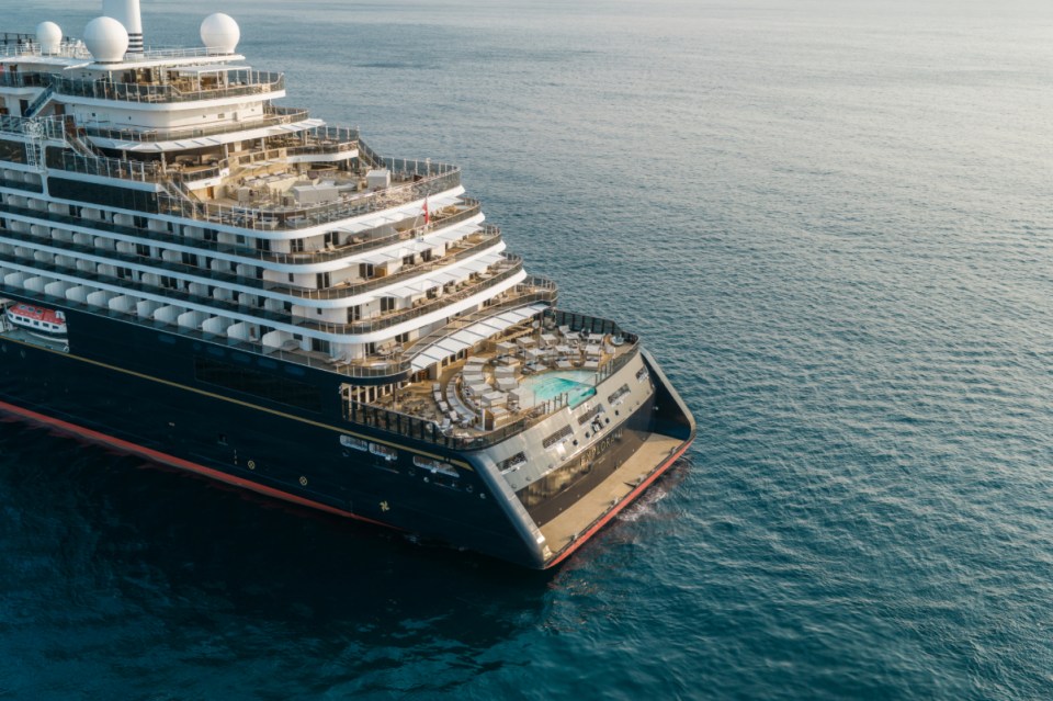 Aerial view of the Explora I luxury cruise ship at sea, showing its stern, decks, and pool area