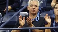 Bill Ackman, CEO of Pershing Square, clapping at the US Open, wearing an American Express lanyard.