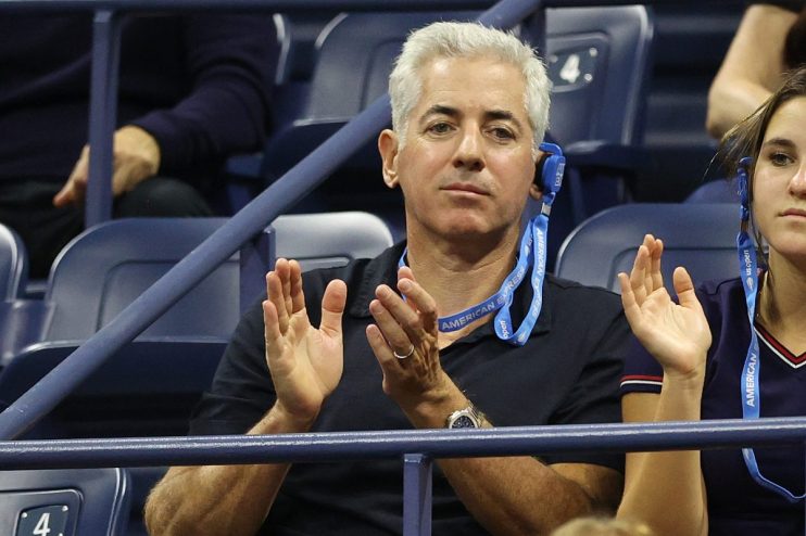 Bill Ackman, CEO of Pershing Square, clapping at the US Open, wearing an American Express lanyard.
