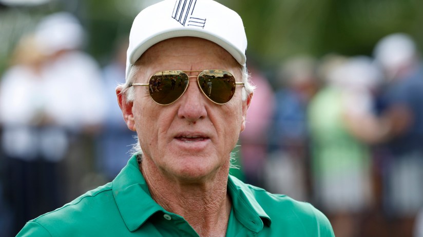 Greg Norman, CEO of LIV Golf, wearing a white cap, sunglasses, and a green polo shirt outdoors.