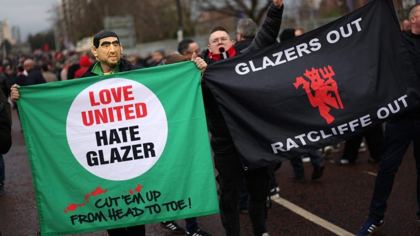 Football fans protest holding Love United Hate Glazer and Glazers Out Ratcliffe Out banners.