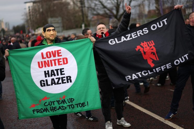 Football fans protest holding Love United Hate Glazer and Glazers Out Ratcliffe Out banners.