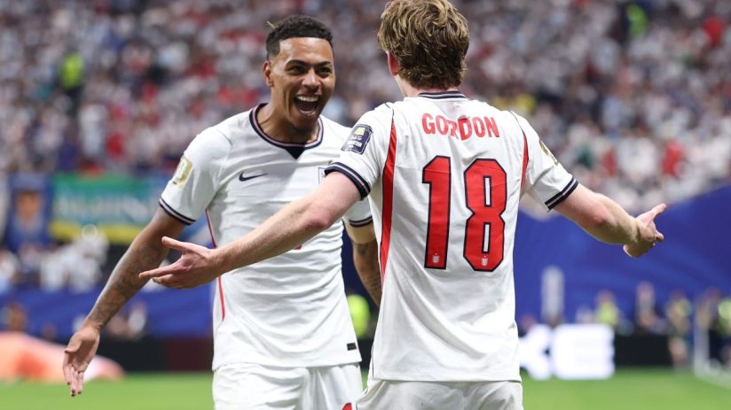 Two jubilant soccer players in white England jerseys celebrate a goal on the field.