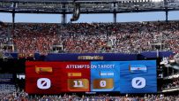 Large stadium scoreboard displaying Attempts on Target for Spain (11) and Argentina (0) with cheering fans.