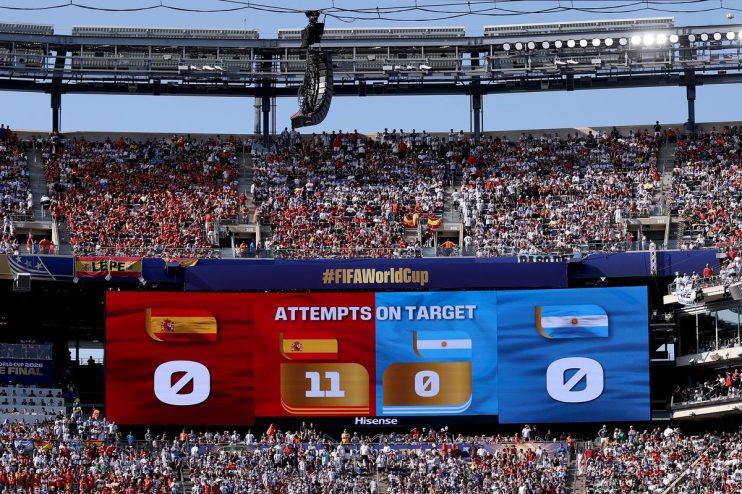 Large stadium scoreboard displaying Attempts on Target for Spain (11) and Argentina (0) with cheering fans.