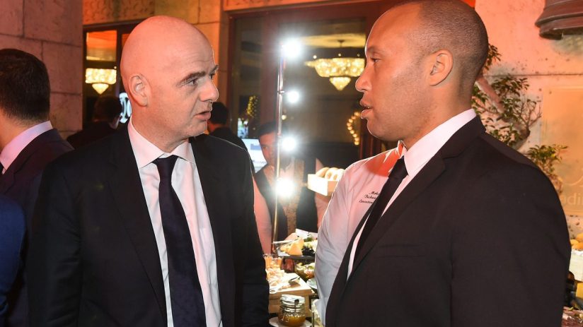 Gianni Infantino speaking with a man in a chefs jacket at a formal event