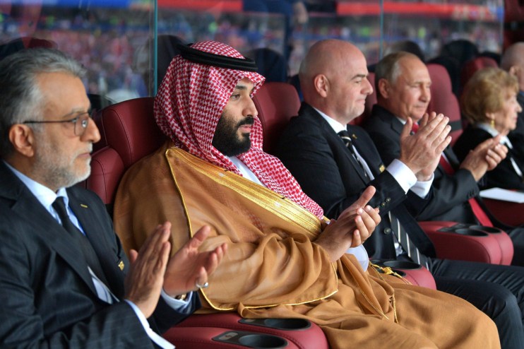 Mohammed bin Salman, Gianni Infantino, and Vladimir Putin applauding at an event.