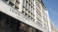 John Lewis & Partners department store building exterior with logo signage against a blue sky