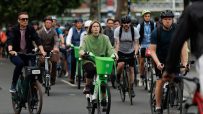 London cyclists ride Lime bikes and personal bicycles on a city street, promoting urban mobility and eco-friendly transport.