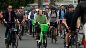 London cyclists ride Lime bikes and personal bicycles on a city street, promoting urban mobility and eco-friendly transport.