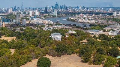 London cityscape from Primrose Hill showing dry, brown grass during drought with River Thames and skyscrapers
