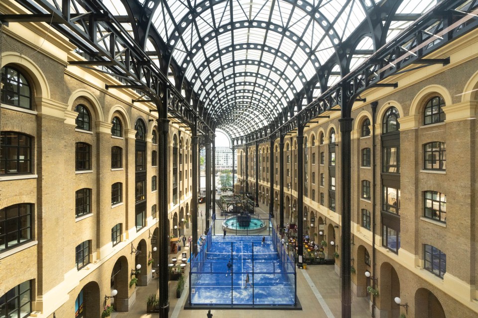 Overhead view of Hays Galleria with a blue padel court and players under a glass archway.