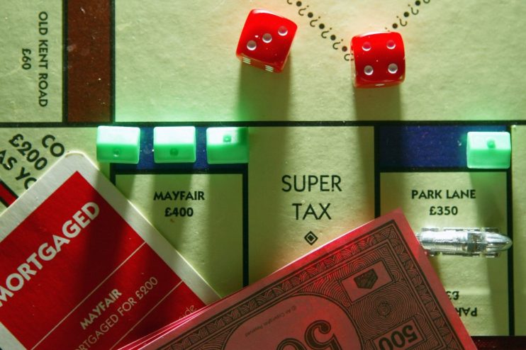 Monopoly board game with Super Tax space, red dice, and property cards, representing taxation concepts.