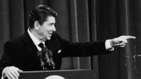 Ronald Reagan at a podium in Washington in 1982, pointing to his right while speaking.