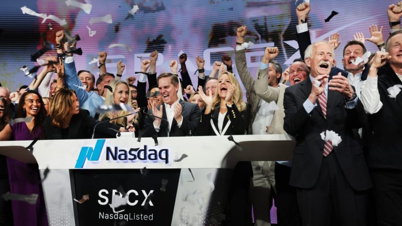 Excited executives celebrating a SpaceX IPO at Nasdaq with confetti falling and fists raised