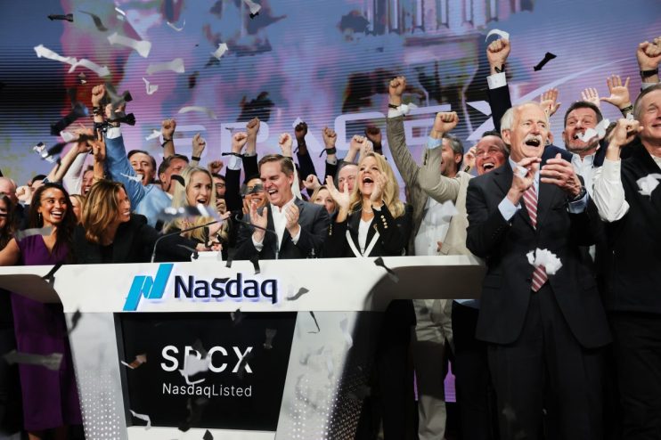 Excited executives celebrating a SpaceX IPO at Nasdaq with confetti falling and fists raised