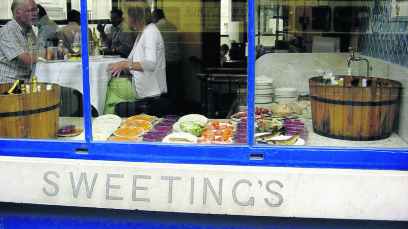 Sweetings City of London restaurant exterior, showing diners inside and a seafood display in the window.