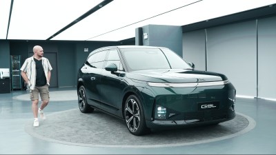 Tim Barnes-Clay observing the new dark green Xpeng G9L electric SUV in a modern showroom in China.