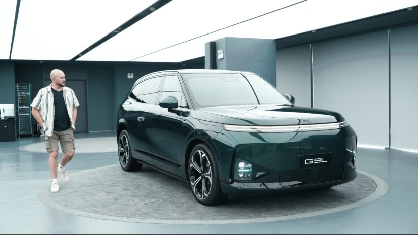 Tim Barnes-Clay observing the new dark green Xpeng G9L electric SUV in a modern showroom in China.