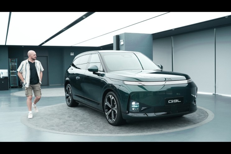 Tim Barnes-Clay observing the new dark green Xpeng G9L electric SUV in a modern showroom in China.