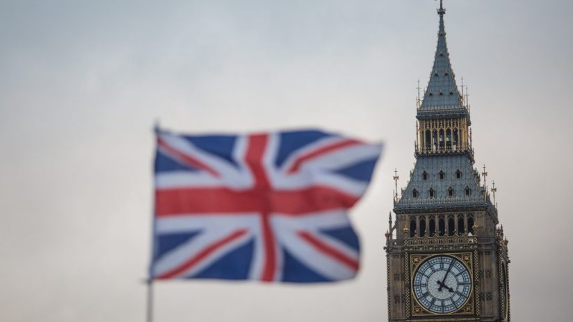 Union Jack flag with Big Ben clock tower and Houses of Parliament in London, UK